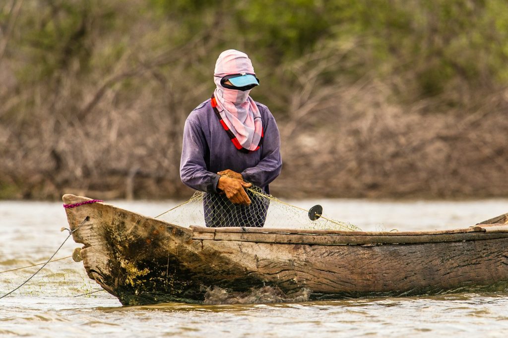 A woman standing in a boat on a river